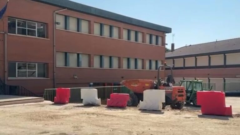 Obras de mejora en el patio de un colegio público con maquinaria de construcción y vallas de seguridad